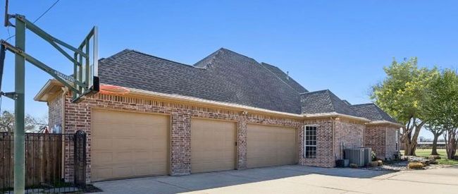 Side entry 3 car garage. The fourth door to the left opens to a 12 x 10 space perfect for lawn equipment, motor bikes or golf carts. | Image 34