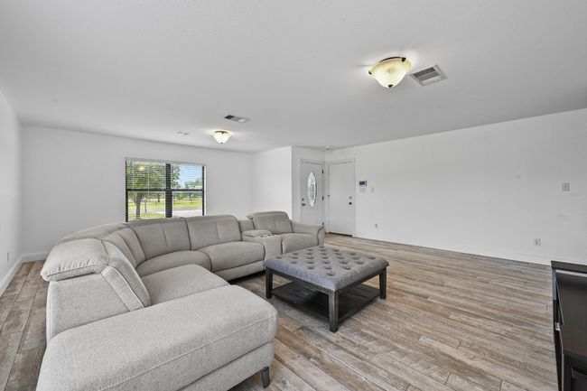 Living room with light wood-style flooring and baseboards | Image 5