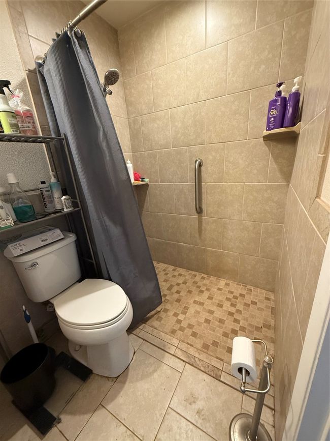 Full bathroom featuring toilet and a stall shower | Image 16