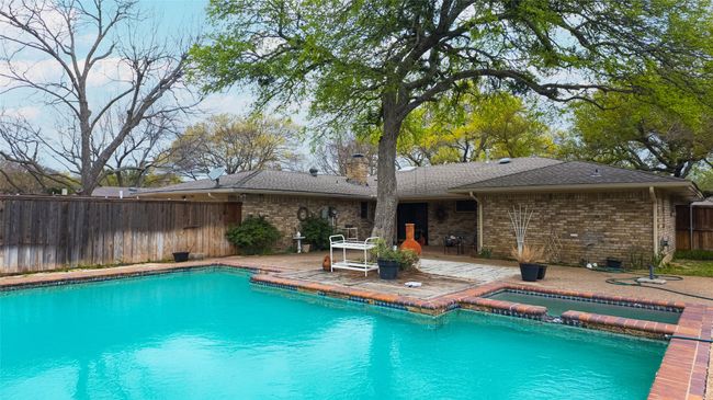View of swimming pool with a patio, a pool with connected hot tub, and a fenced backyard | Image 8