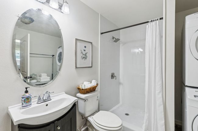 3rd Bathroom En- Suite in Mother in Law suite with stacked washer / dryer, vanity, and a tile shower | Image 20