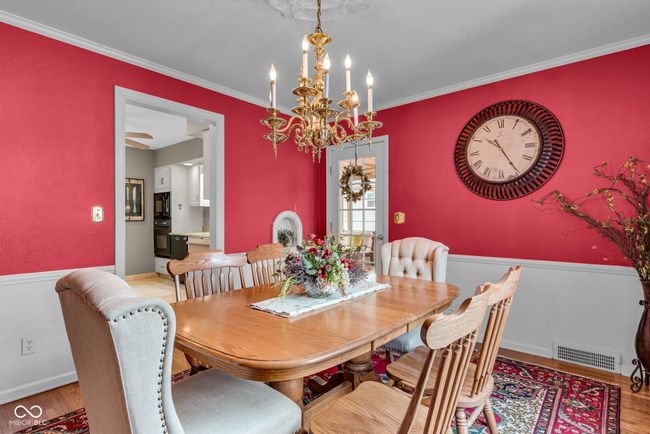 dining room featuring ornamental molding, a notable chandelier, light wood finished floors, and visible vents | Image 14