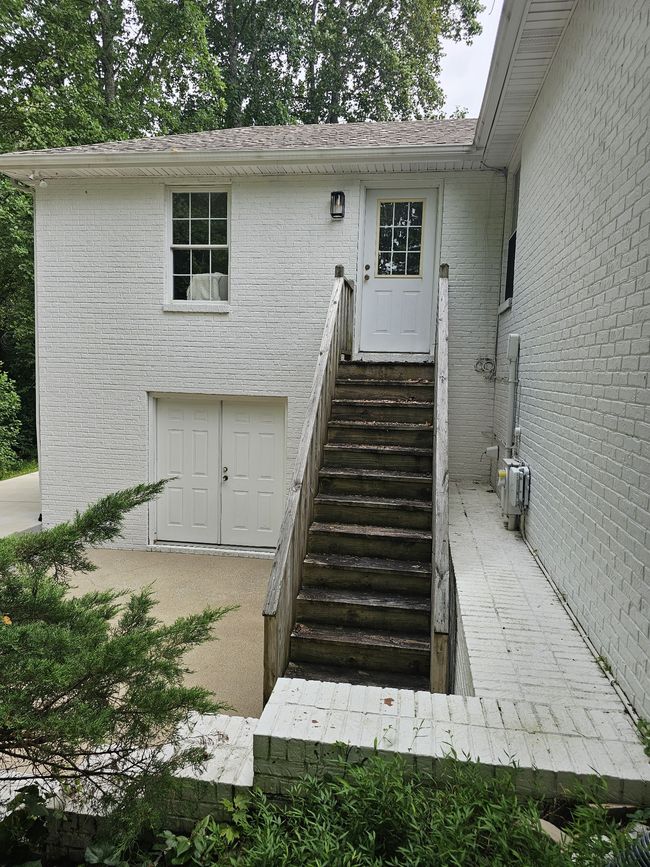 Steps leading to den. Door leading to basement storage and another patio. Great for grilling. | Image 39