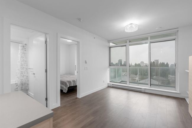 Unfurnished bedroom with baseboards, wood finished floors, and baseboard heating | Image 4