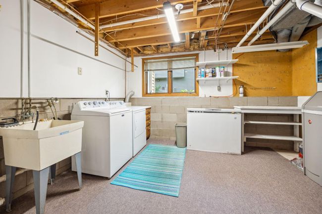 Laundry with sink, utility and workshop space. Lower level garage entry just outside this room. | Image 23