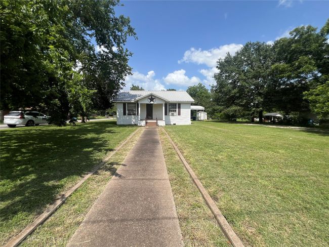 Front lawn, a metal roof, and a porch | Image 23