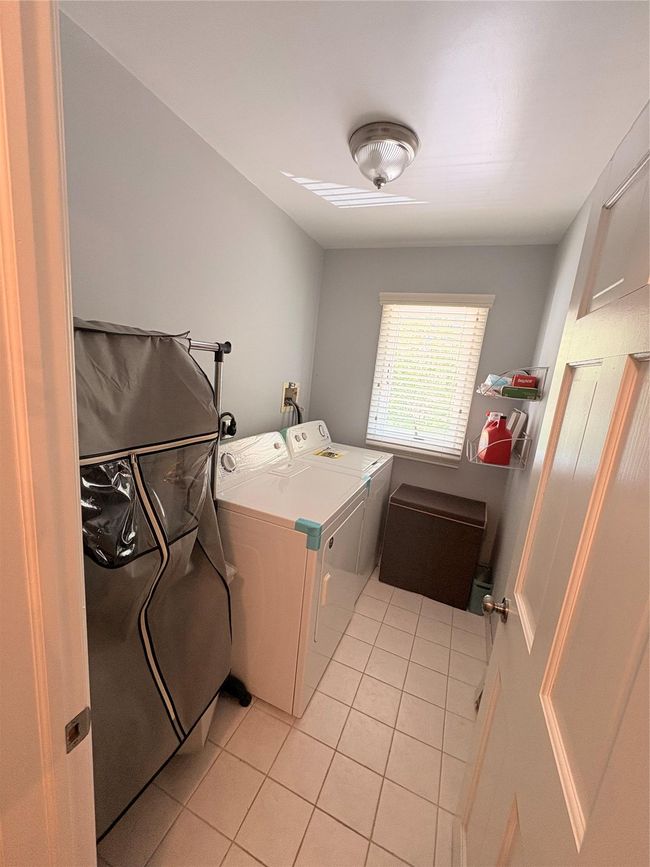 Laundry room featuring light tile patterned floors and independent washer and dryer | Image 14