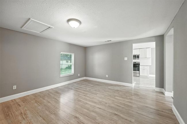 Unfurnished room featuring light wood-type flooring, attic access, and a textured ceiling | Image 5