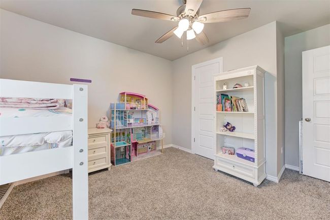 Carpeted bedroom with a ceiling fan and baseboards | Image 32