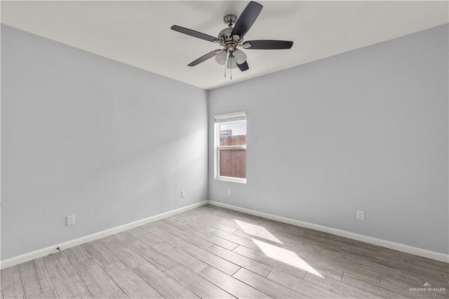 Spare room with wood finished floors, baseboards, and ceiling fan | Image 4