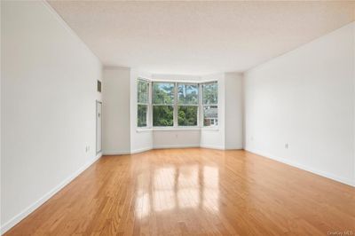 Empty room with light hardwood / wood-style floors and a textured ceiling | Image 1