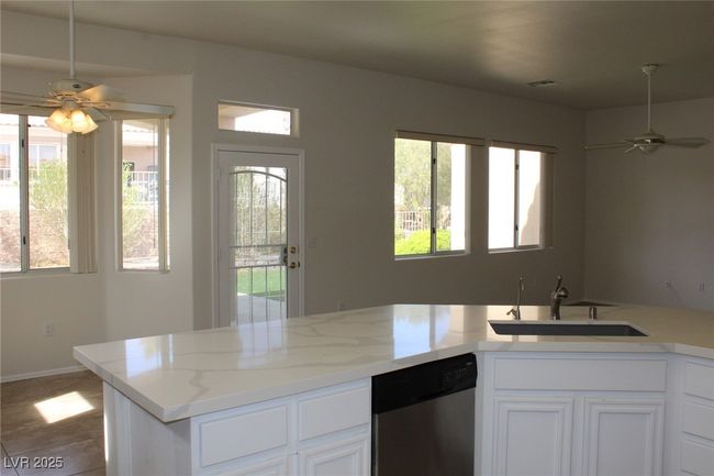 Kitchen featuring plenty of natural light, a ceiling fan, stainless steel dishwasher, and a sink | Image 12