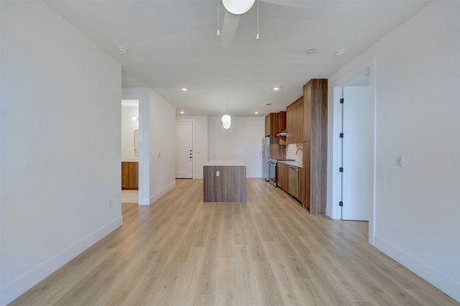 Unfurnished living room featuring light wood-style flooring, ceiling fan, and recessed lighting | Image 8