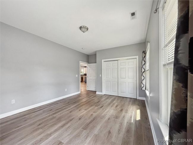Unfurnished bedroom featuring wood finished floors, a closet, and baseboards | Image 17