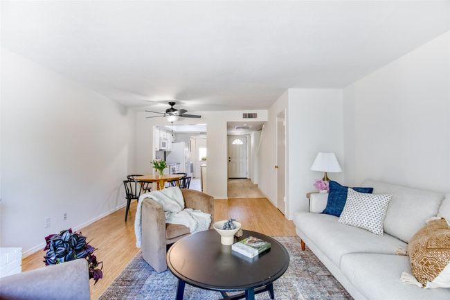 Living area featuring a ceiling fan and light wood-style flooring | Image 11