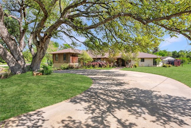 Ranch-style home with curved driveway and a front lawn | Image 4
