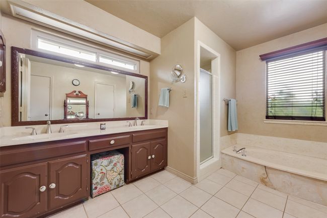 Bathroom featuring tile patterned floors, plenty of natural light, a stall shower, and double vanity | Image 22