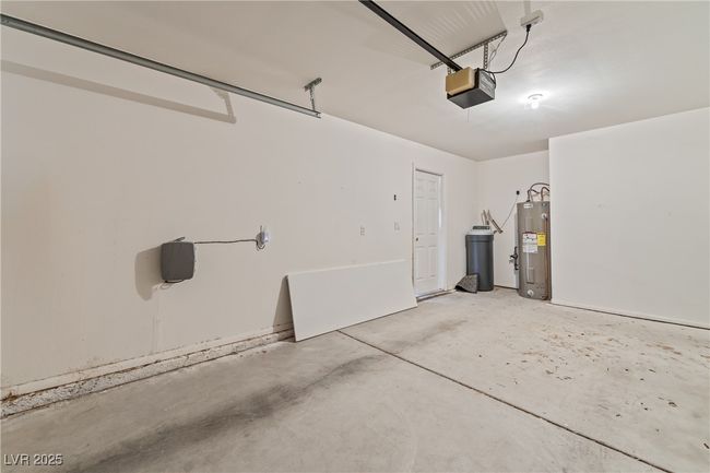 Garage featuring electric water heater and a garage door opener | Image 31
