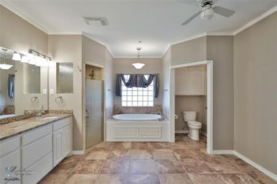 Full bathroom with vanity, crown molding, toilet, ceiling fan, and independent shower and bath | Image 2