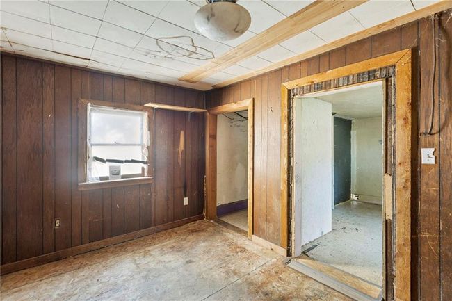 Unfurnished bedroom featuring wood walls and a closet | Image 14