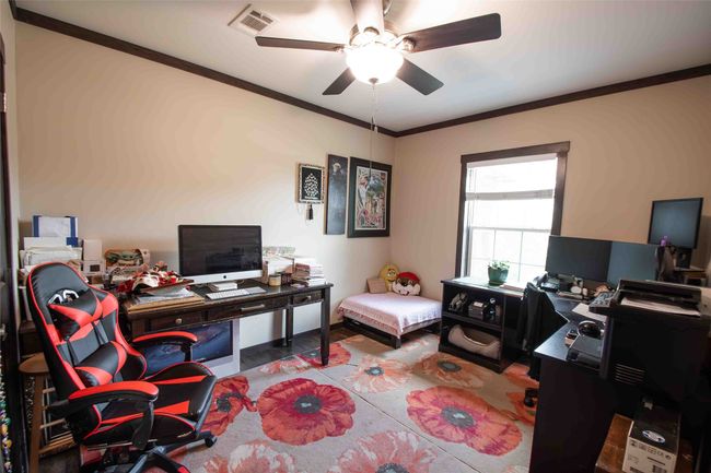 Third bedroom used as Office area featuring ceiling fan and crown molding | Image 24
