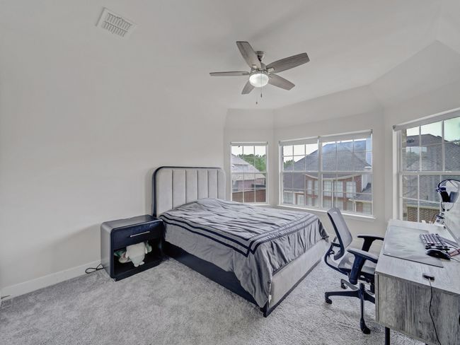 Bedroom with carpet, baseboards, ceiling fan, and a desk | Image 22