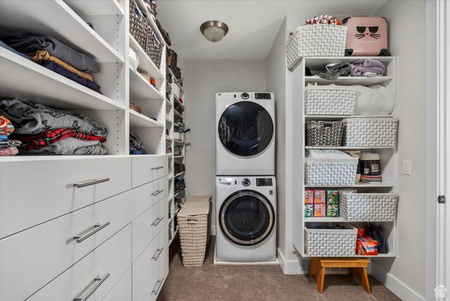 Laundry room with laundry area, stacked washer and dryer, baseboards, and carpet floors | Image 29
