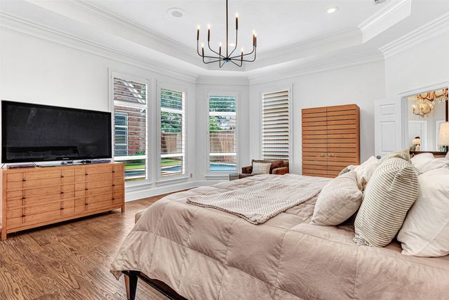 Your private primary suite has a sunny bay window with plantation shutters and an amazing designer chandelier. | Image 24