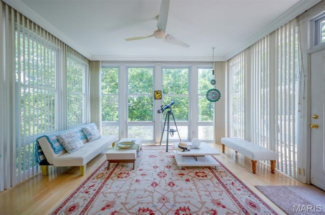 Sunroom / solarium with wood finished floors and crown molding | Image 17