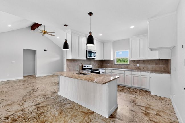 Kitchen featuring light stone counters, white cabinets, backsplash, stainless steel appliances, and recessed lighting | Image 18