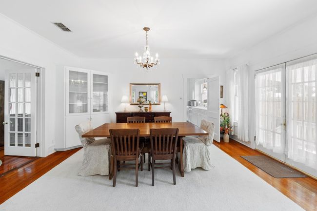 Dining space with wood finished floors and a chandelier and side french doors to side porch | Image 8