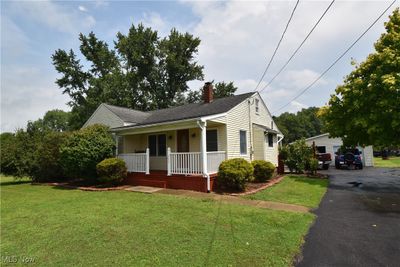 View of front of home featuring a porch, a garage, and a front lawn | Image 1