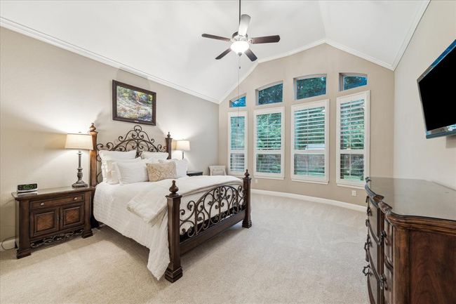 STOP! Take a breath and appreciate this AMAZING primary suite. Plantation shutters, high ceiling, and tranquil view of the back yard oasis. | Image 15