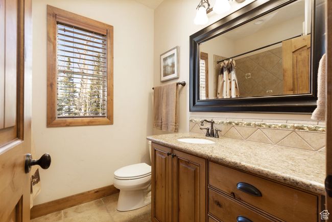 Full bathroom featuring tile patterned floors, a shower with shower curtain, toilet, vanity, and baseboards | Image 38