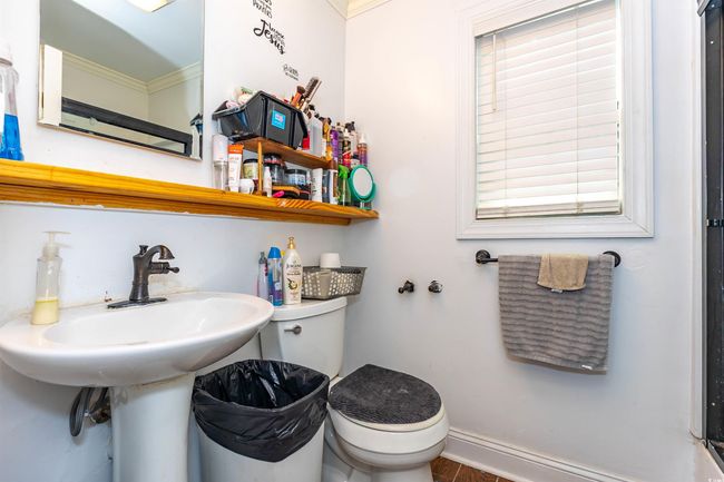 Half bathroom featuring baseboards, crown molding, and toilet | Image 9