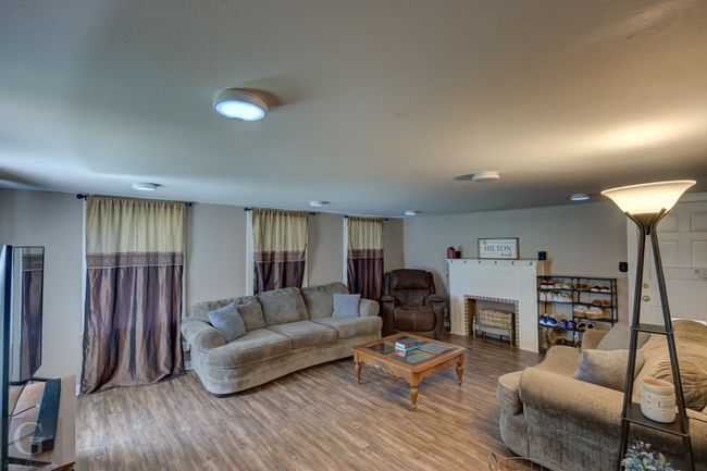 Living area featuring wood finished floors and a brick fireplace | Image 7