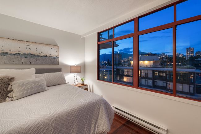 Bedroom featuring baseboard heating, a view of city, and wood finished floors | Image 26