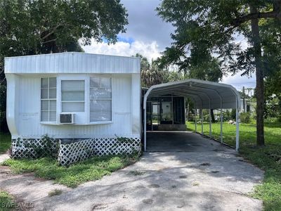 View of vehicle parking with a yard and a carport | Image 2