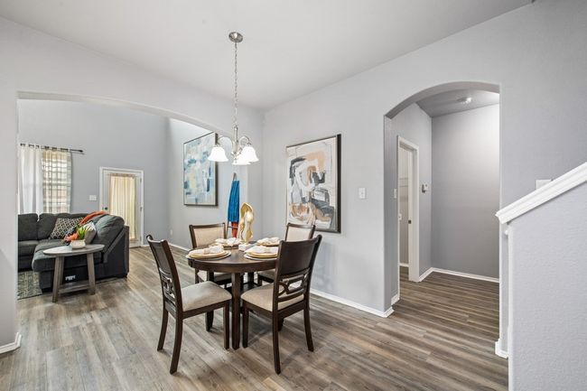 Dining area with baseboards, arched walkways, a chandelier, and wood finished floors | Image 16