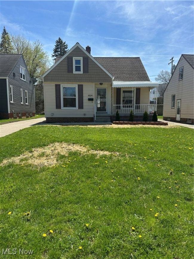 View of front of home with covered porch, a chimney, and a front lawn | Image 5