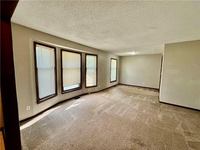 Carpeted front living room featuring a wealth of natural light and a textured ceiling | Image 2