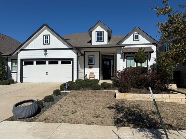 View of front of house with concrete driveway, board and batten siding, a garage, roof with shingles, and a porch | Image 21