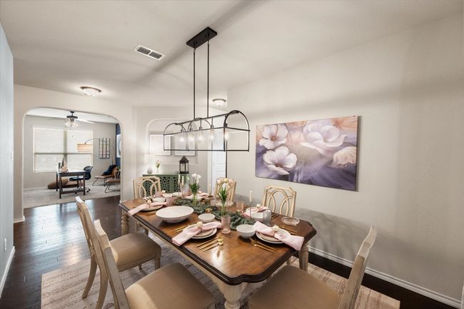 Dining space featuring arched walkways, visible vents, baseboards, and dark wood finished floors | Image 7