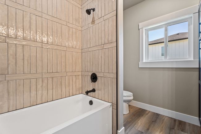 Full bath featuring baseboards, toilet, wood finished floors, and tub / shower combination | Image 25
