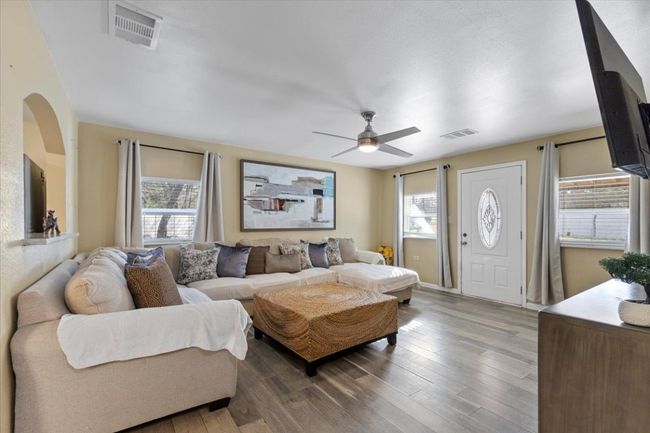 Living area with a wealth of natural light, visible vents, and wood finished floors | Image 15