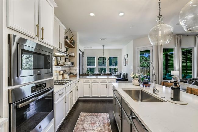 Kitchen featuring a sink, dark wood finished floors, recessed lighting, stainless steel appliances, and backsplash | Image 10