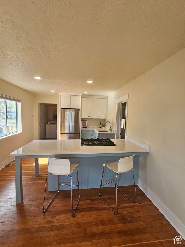 Kitchen featuring stainless steel refrigerator, a sink, a breakfast bar area, custom cabinets | Image 10