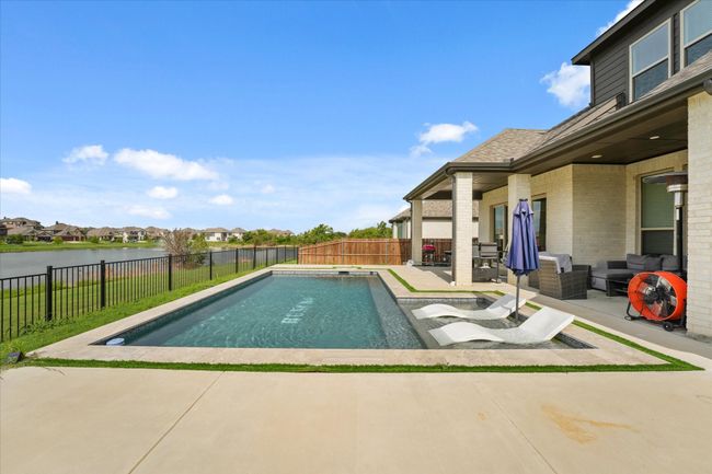 View of swimming pool with a patio, a fenced backyard, an outdoor living space, and a water view | Image 29