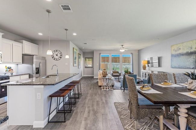 Kitchen featuring stainless steel appliances, open floor plan, dark stone countertops, wood finished floors, and recessed lighting | Image 7