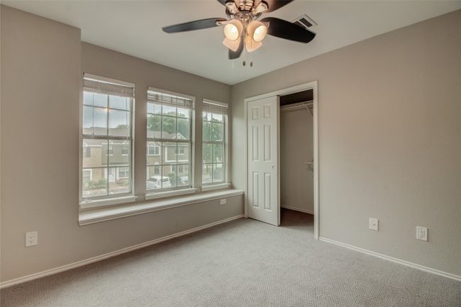 Unfurnished bedroom with multiple windows, carpet floors, baseboards, and a closet | Image 25